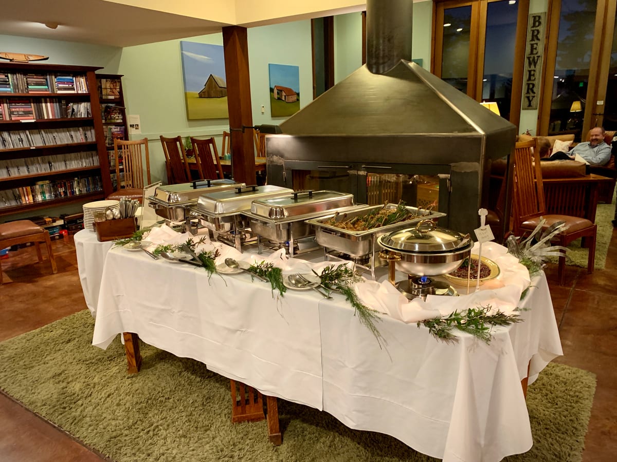 A buffet laid out for a group beside the library and fireplace at Brewery Gulch Inn