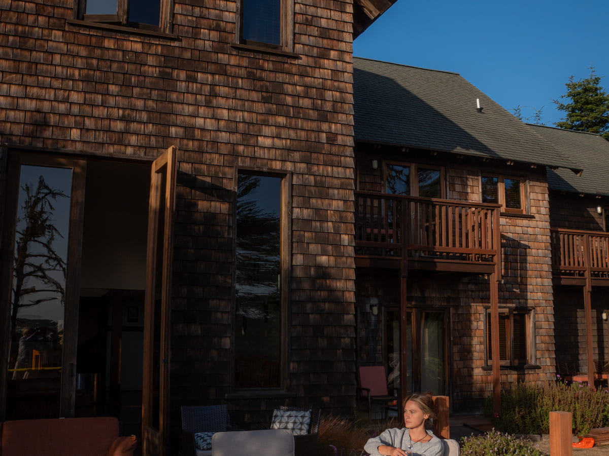 The redwood-shingled exterior of Brewery Gulch Inn at golden hour